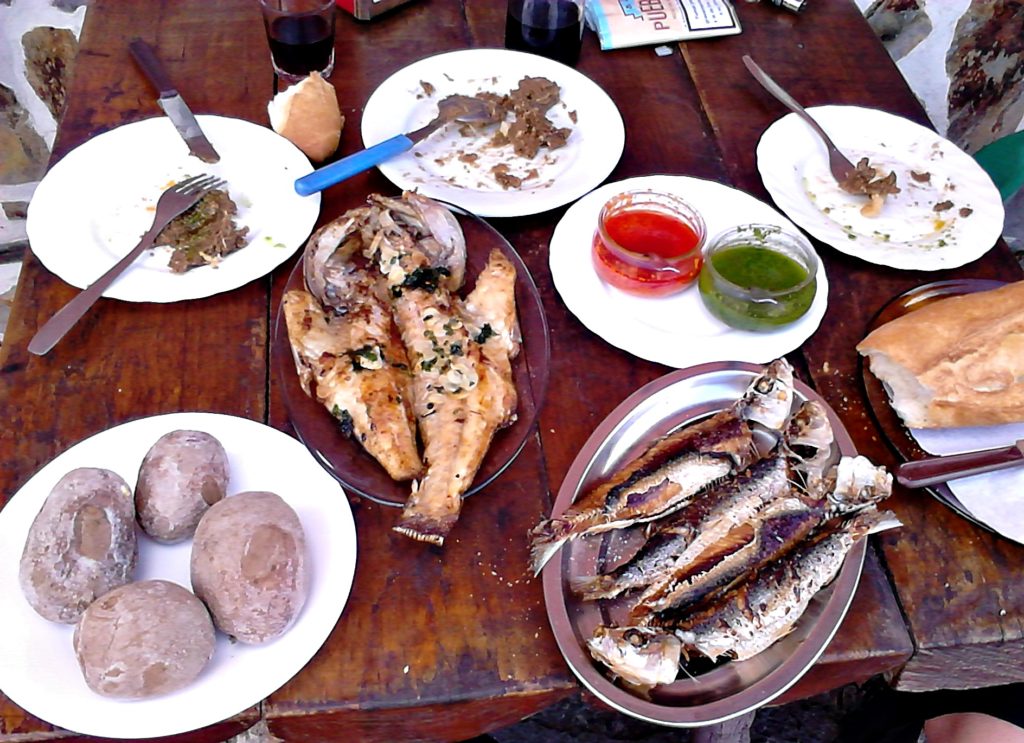 Imagen de una mesa con típica comida canaria con papas arrugás y mojo rojo y verde, entre otras delicias (Tenerife, Islas Canarias, España)