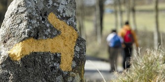 Una flecha amarilla que señala el Camino pintada en una roca.